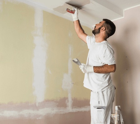 Peintre en train d'appliquer de la peinture sur un plafond à Labenne